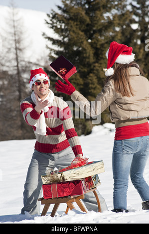 Couple in Christmas outfit, throwing a present Stock Photo