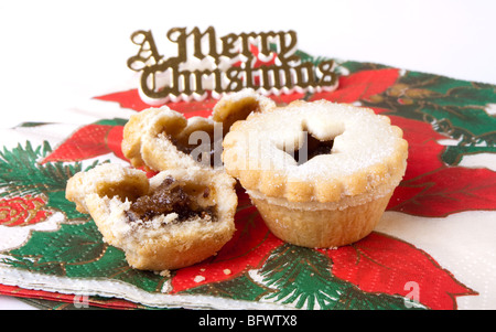 Sweet Mince Pies resting on christmas themed napkins Stock Photo