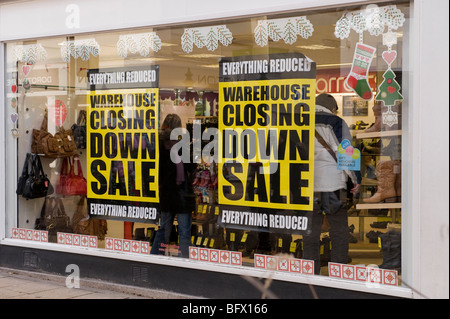 Shoe shop window displaying 'closing down' posters. Stock Photo