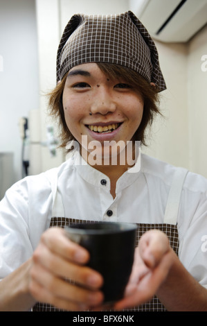 Being served a cup of kurozu vinegar and water, Kurozu Bar, Shimbashi station, Tokyo, Japan, November 27 2009. Stock Photo