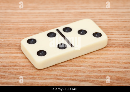 One tile dominoes lying on a wooden surface close up Stock Photo