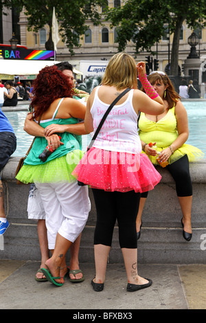 Group of women wearing bright colored tutu skirts in Trafalgar Square London during a hen party Stock Photo