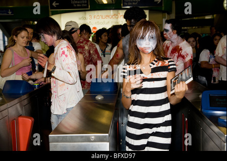 Group of Zombies walking out from sky train at First zombie walk festival in Bangkok, Thailand. Stock Photo