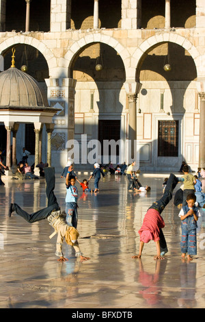 Muslim girls doing flips in the Umayyad Mosque in Damascus Syria Stock Photo