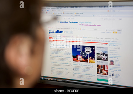 Woman reading the news from the Guardian online website Stock Photo