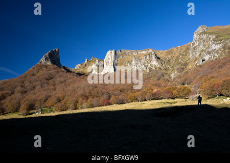 A hiker photographing the Chaudefour valley, in Autumn (France). Randonneur photographiant la vallée de Chaudefour, en automne. Stock Photo