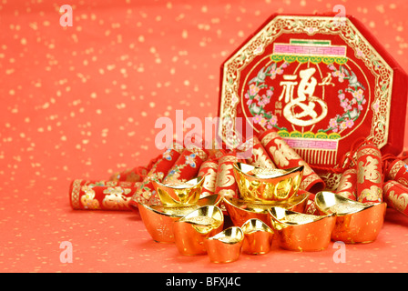 Chinese traditional fire crackers and ingot on a festive background. Stock Photo