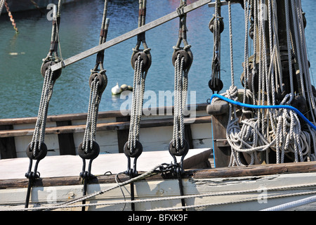 Ropes in wooden blocks / pulleys on board of a sailing ship, Brittany, France Stock Photo