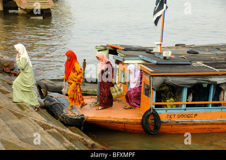 Malay or Malaysian Muslim Women in Islamic Dress Leave a Ferry Boat on the Waterfront at Kuala Terengganu, Malaysia Stock Photo