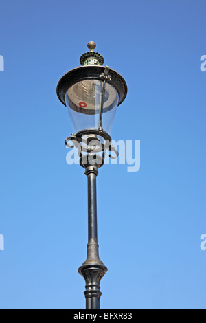 Old fashioned and antique wrought iron street lamp in Nyhavn, Copenhagen, Denmark - on a blue sky. Stock Photo