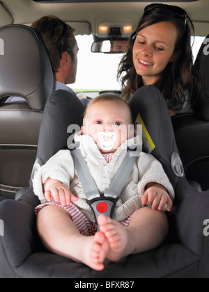 mother watching baby in car seat Stock Photo