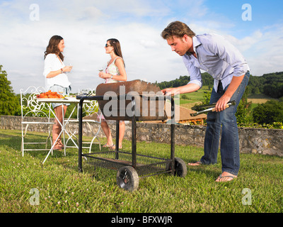 man tending barbecue Stock Photo