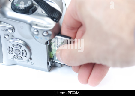 A closeup of a hand inserting a compact flash memory card into a digital SLR camera. Stock Photo