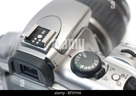 A closeup of the top of a digital SLR camera, with focus on the mode dial and on/off switch, isolated on white. Stock Photo