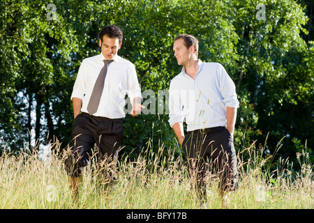 two businessmen talking in field Stock Photo