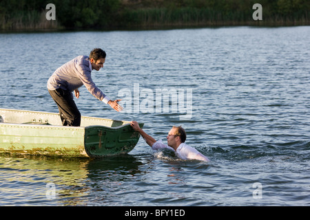 businessman helping man overboard Stock Photo