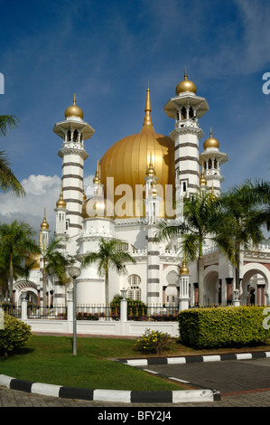 Golden Dome & Minarets of Masjid Ubudiah or Ubudiah Royal Mosque (1917) by Arthur Benison Hubback framed by Palm Trees Kuala Kangsar, Perak, Malaysia Stock Photo