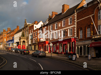 View of the high street in the town centre of Ashbourne in the Derbyshire Peak District England UK showing shops and parked cars Stock Photo