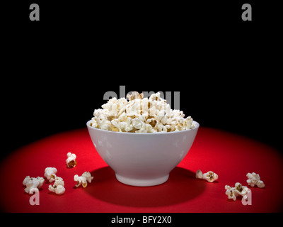 A bowl full of popcorn under the spotlight. Stock Photo