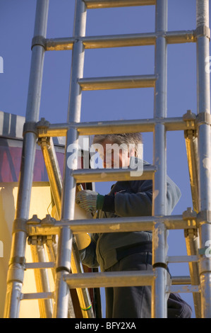 Woman on tower scaffolding painting house Stock Photo