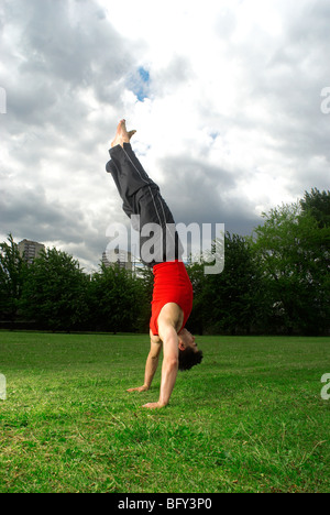 man doing handstand in park Stock Photo