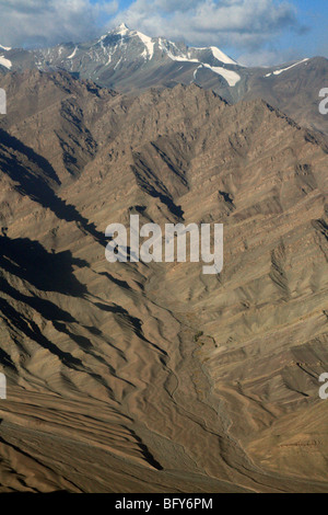 Peak to valley view near Leh  Zanskar Indian Himalaya foothills and stream beds in the Indus valley to snowy peaks above. Stock Photo