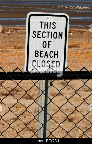 Sign and fence indicating beach is closed Stock Photo