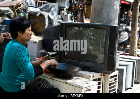 Cooking by old tv sets in the streets of Nanjing, China. Stock Photo