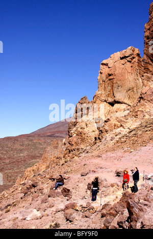 TOURISTS CLIMB THE LAVA ROCK FORMATIONS WITHIN THE TEIDE NATIONAL PARK ON THE CANARY ISLAND OF TENERIFE. Stock Photo