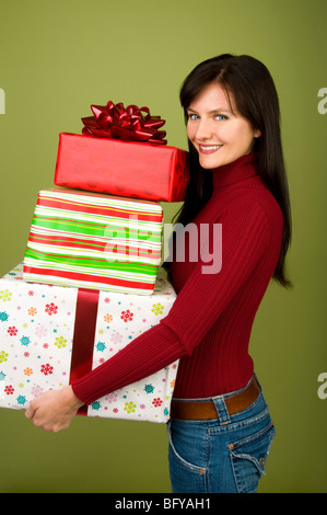Woman holding stack of Christmas gifts Stock Photo