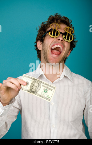 Businessman wearing dollar sign sunglasses and holding money Stock Photo