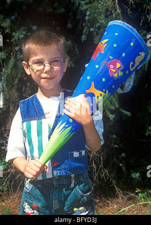 boy with a cornet of cardboard filled with sweets and little presents given to children in Germany on their first day at school Stock Photo