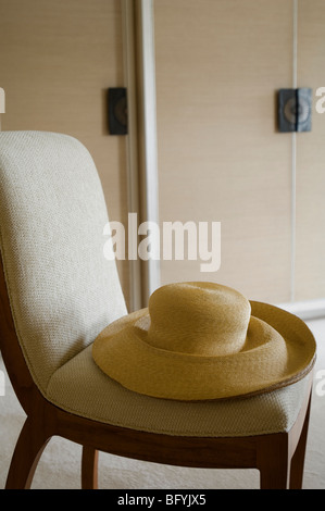 Hat on a chair in the London apartment of designer Emily Todhunter Stock Photo