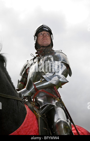 Medieval knight in shining armor on black horse