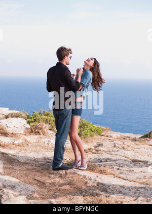 couple standing at cliff holding hands Stock Photo