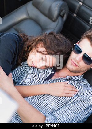 couple lying in open-topped car Stock Photo