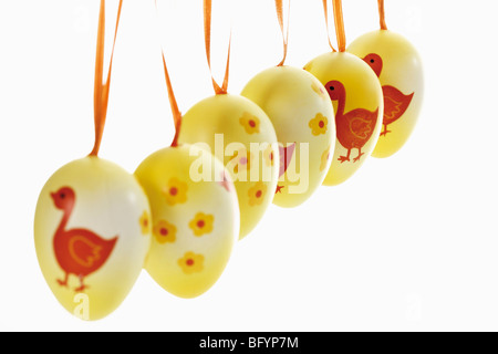Artfully painted Easter eggs hanging from ribbons Stock Photo