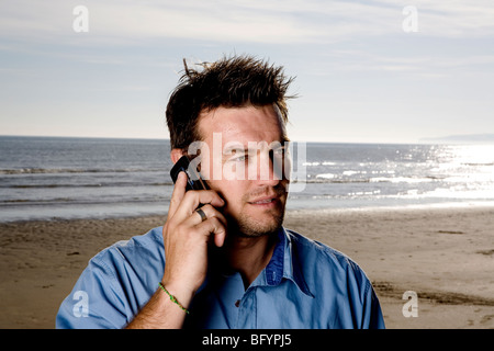 A man using his cellphone at the beach, Stock Photo