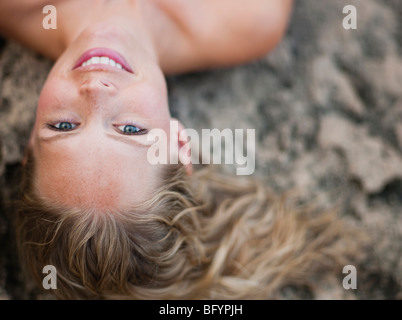 woman lying on rocks looking at viewer Stock Photo