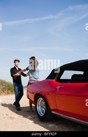 couple holding hands next to car Stock Photo