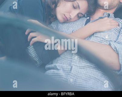 couple lying in open-topped car Stock Photo