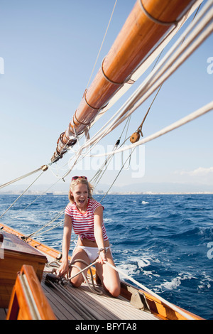 woman holding on to ropes on deck Stock Photo