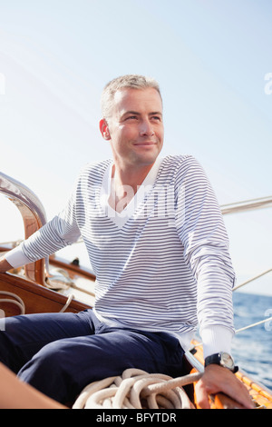 man smiling sitting on deck Stock Photo