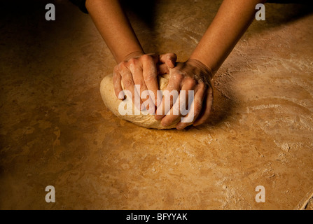 Person kneading bread dough on a marble surface, close up looks very old world Stock Photo