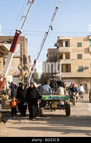 Pedestrians cross railway tracks in back streets of Luxor Egypt Stock Photo