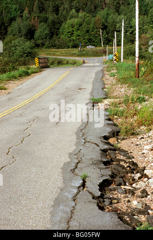 Dangerous Road Conditions - Soil Erosion along Side of Asphalt Highway creates Cracked and Broken Pavement Stock Photo