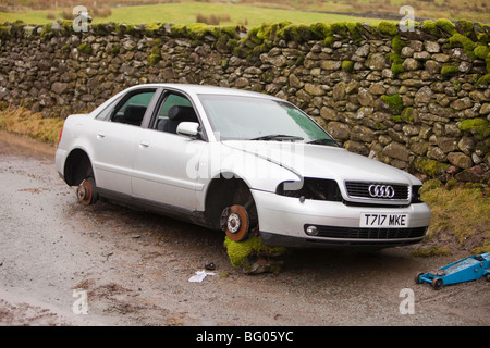 a car that had its wheels stolen after being abandoned in the floods on kirkstone pass above Ambleside, Lake district, Stock Photo