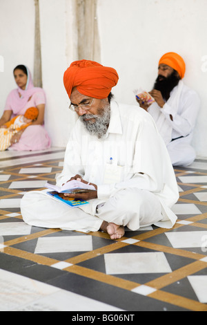 Sikh man reading holy texts in Golden Temple, Amritsar, India. Stock Photo