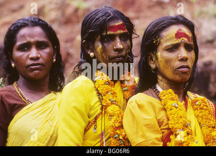 Three South India women wait in line to participate in a fire walking festival in the state of Tamil Nadu. Fire walking is an important ritual practiced by certain sections of Hindu society. The ritual is practiced by many Hindus in south India. The ritual is primarily dedicated to Amman an important female deity associated with the Shakti cult in South Indian and Tamil culture. The fire walking ritual is an act of self-purification. For some of these devotees it is part of a vow in which the devotee promises to walk on fire in exchange for a wish or a blessing by Amman. Stock Photo