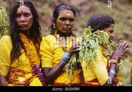 Three South India women wait in line to participate in a fire walking festival in the state of Tamil Nadu. Fire walking is an important ritual practiced by certain sections of Hindu society. The ritual is practiced by many Hindus in south India. The ritual is primarily dedicated to Amman an important female deity associated with the Shakti cult in South Indian and Tamil culture. The fire walking ritual is an act of self-purification. For some of these devotees it is part of a vow in which the devotee promises to walk on fire in exchange for a wish or a blessing by Amman. Stock Photo